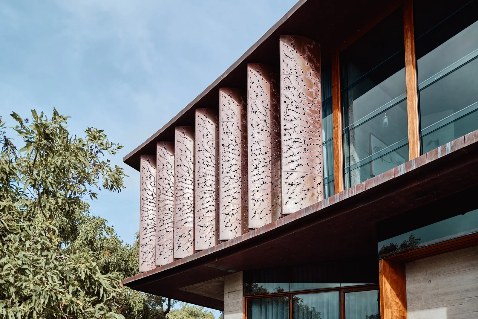 Laser-cut perforated copper louvers with organic patterning — bespoke screen panels by Euroclad